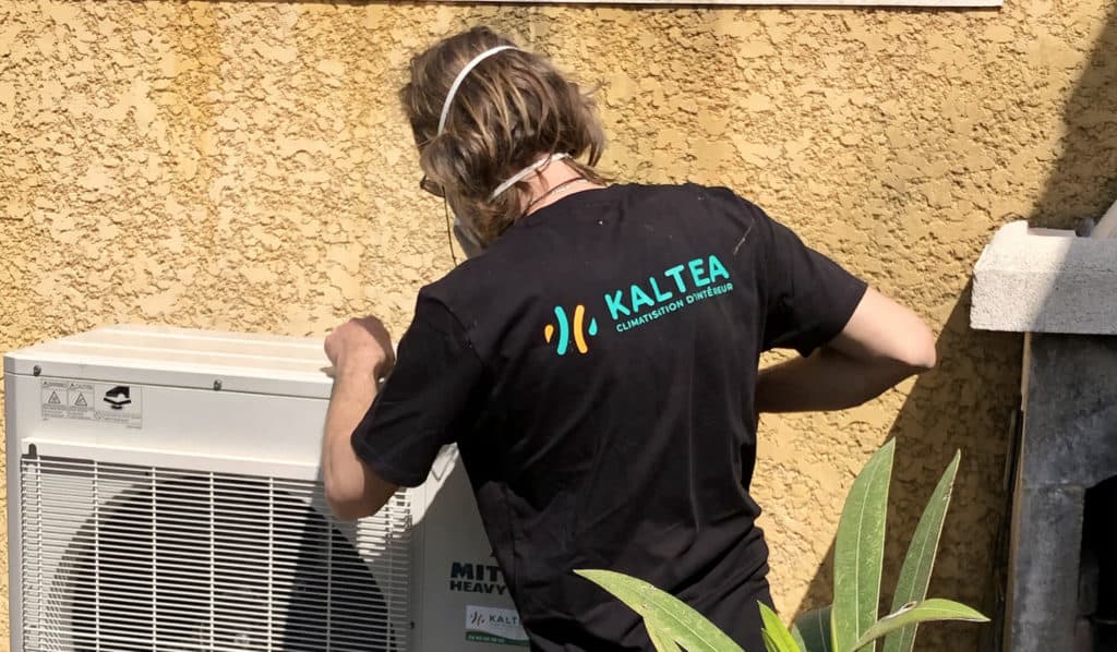 Technicien KALTEA entrain de poser un groupe exterieur de climatisation réverssible