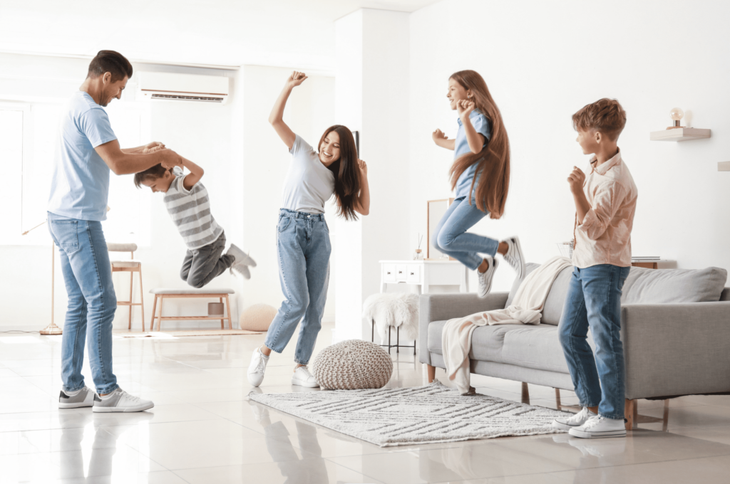 Une famille heureuse dans son salon, et au frais en plein été, grace à une climatisation réversible.