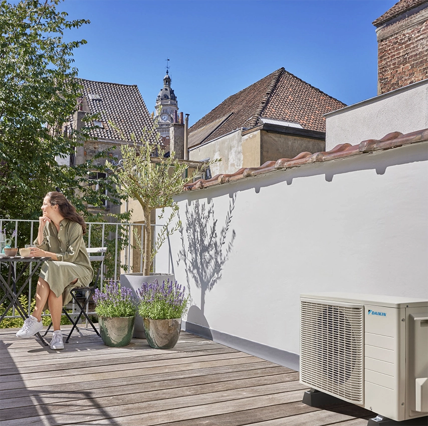 Pompe à chaleur Daikin installée sur une terrasse ensoleillée pour le confort thermique d’un logement.