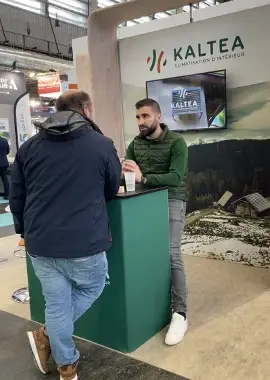 Échange entre un visiteur et un membre du réseau KALTEA sur le stand du salon Franchise Expo Paris.